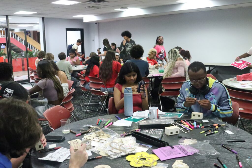A group of students works downstairs at the arts and crafts station.