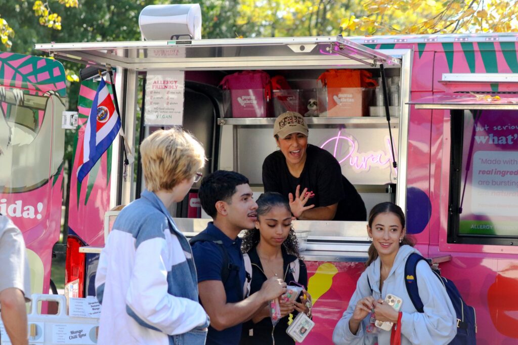 MONTCLAIR, NJ. 10-14-2026. HISPANIC HERITAGE MONTH BLOCK PARTY - ICE CREAM: On October 14th 2026, An Ice Cream truck was at the center of the quad serving ice creams to students at Montclair State University. The company is called Puras Paletes and it is latina owned by a woman named Pamela Alfaro who can be seen handing out her treats to all who came by. Photograph taken by Estefano Quispe.